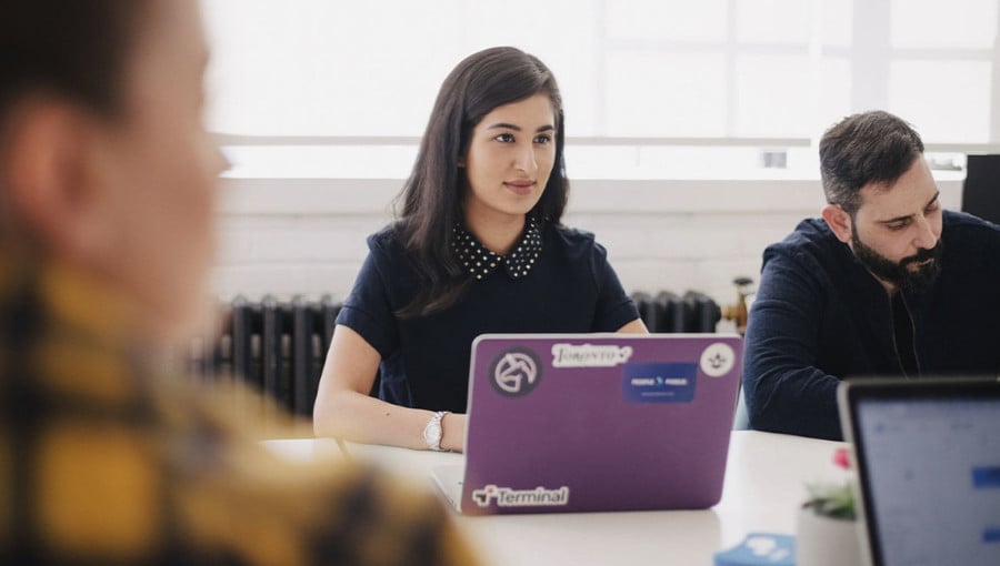 Woman in a class with her laptop staring