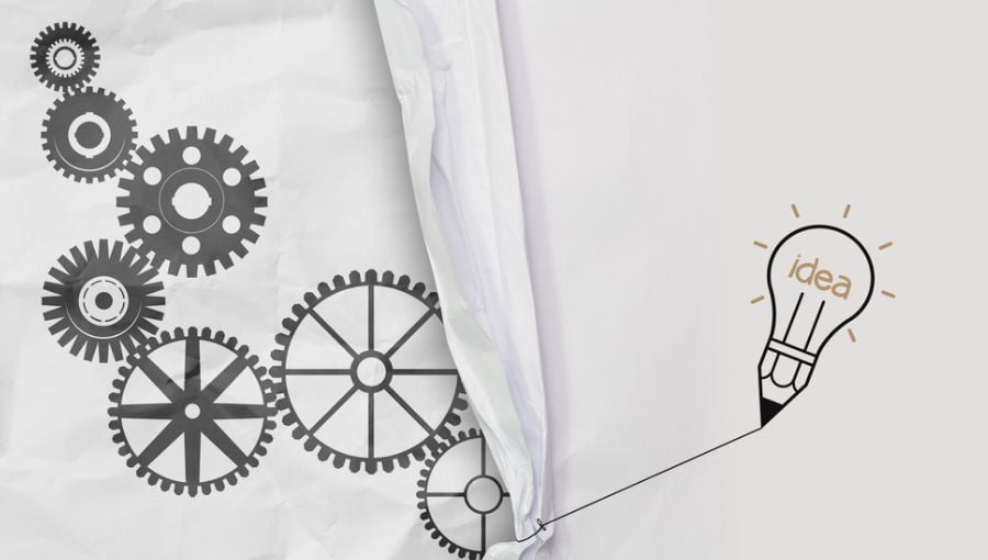 Cross functional collaboration: What it is, barriers and best practices - lightbulb and cogwheels on a paper