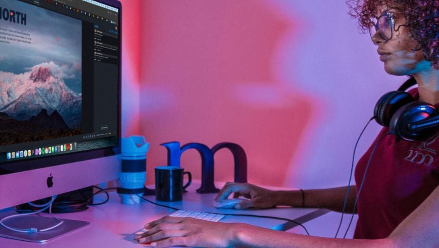 Designer working on content review by her desk and desktop computer