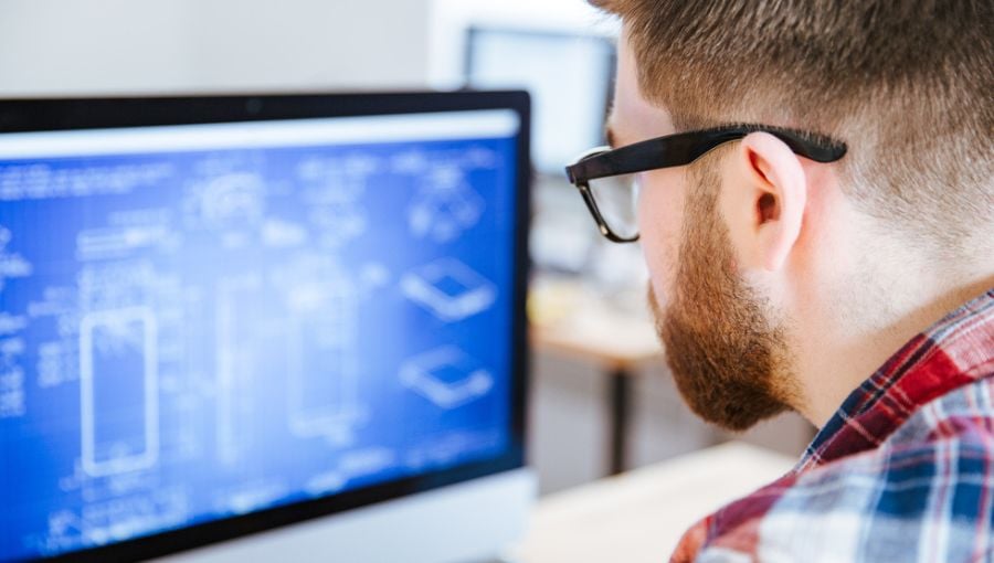 Graphic designer working on creative project blueprint using design tools on a desktop computer