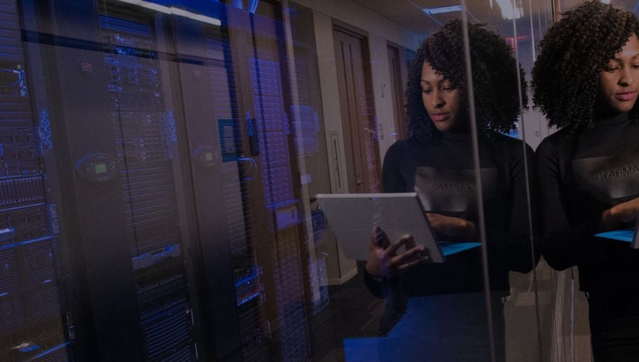 Software architect working in a server room on her laptop