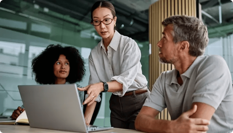 Creative team reviewing work together on a laptop