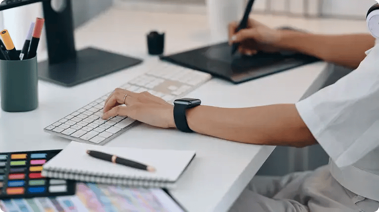 Designer working on a tablet and keyboard in a creative studio