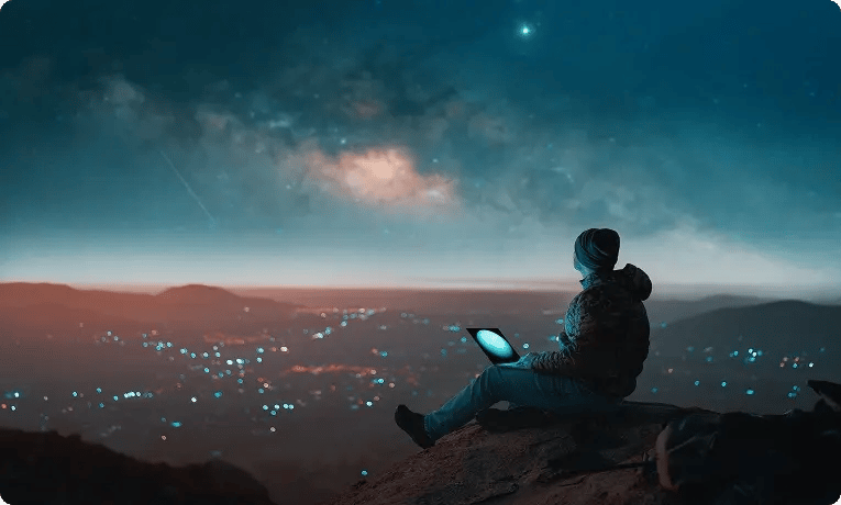 Person using a connected device in a remote location under a night sky