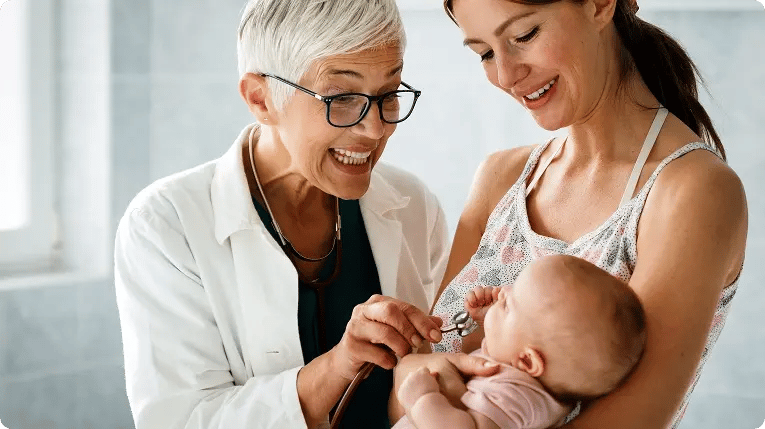 Pediatrician examining a baby held by their mother