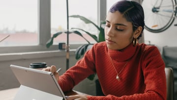 woman in red blouse using tablet - blog post featured image